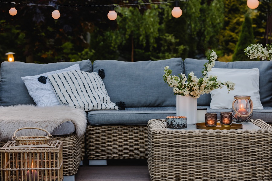 Eine Terrasse mit Rattanmöbeln und Kerzen als Schutz gegen Insekten.